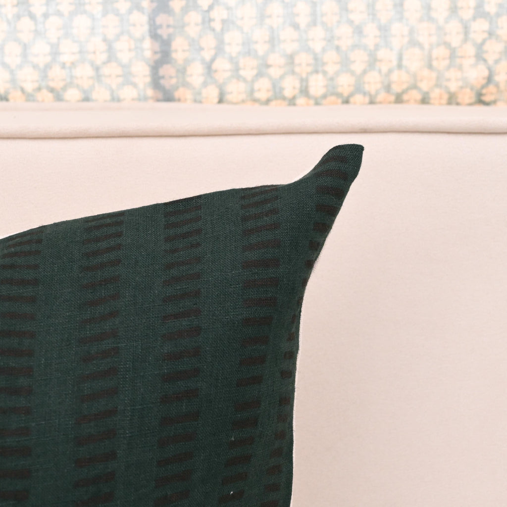 Close-up of hand block printed geometric dash stripe on forest green linen