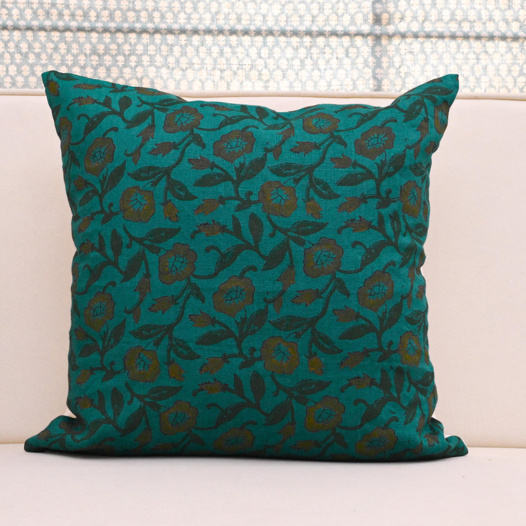 Teal wild rose vine block print linen pillow cover styled on a sofa
