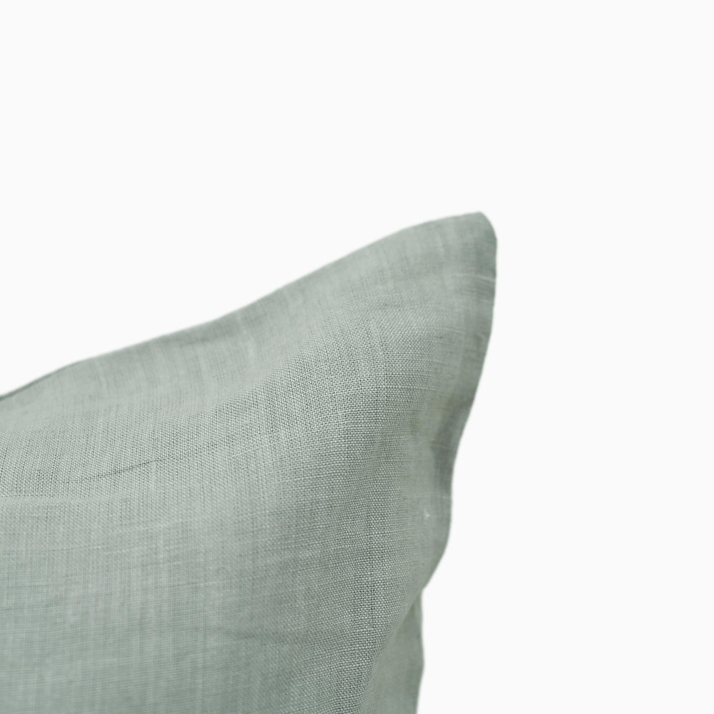 Close-up of sage linen pillow cover fabric texture and stitching