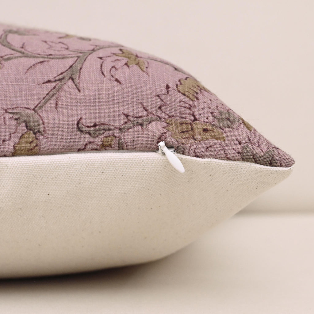 Close-up of gold floral block print detail on mauve linen pillow cover