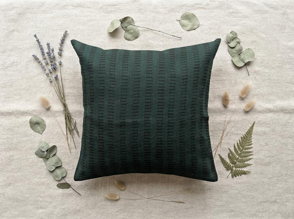 Forest green geometric stripe linen cushion cover on a sofa