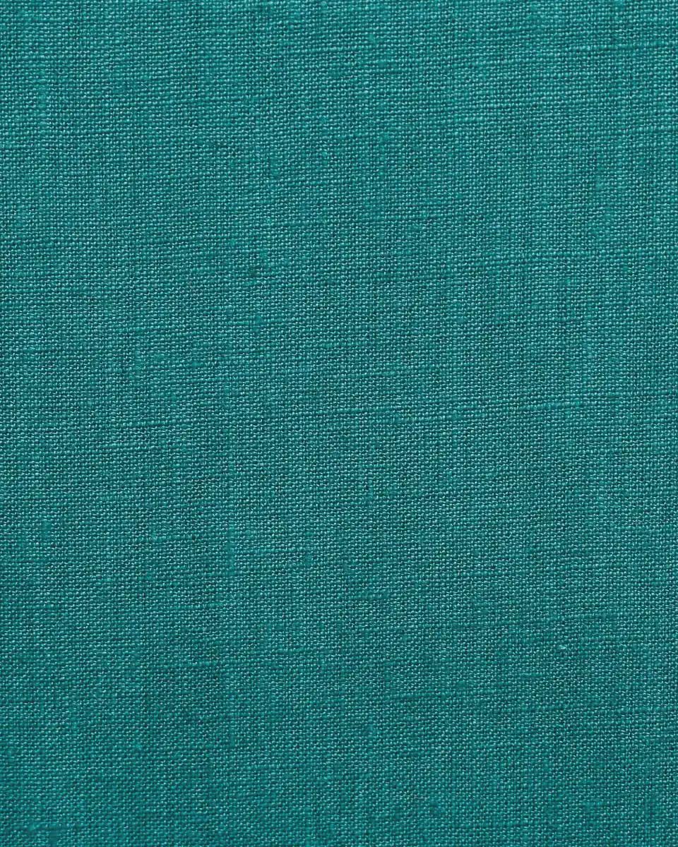 Deep teal linen pillow cover shown at an angle highlighting fabric drape