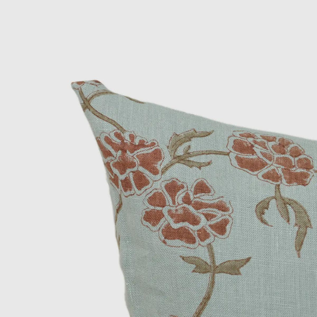 Dusty blue botanical linen cushion cover styled on a sofa
