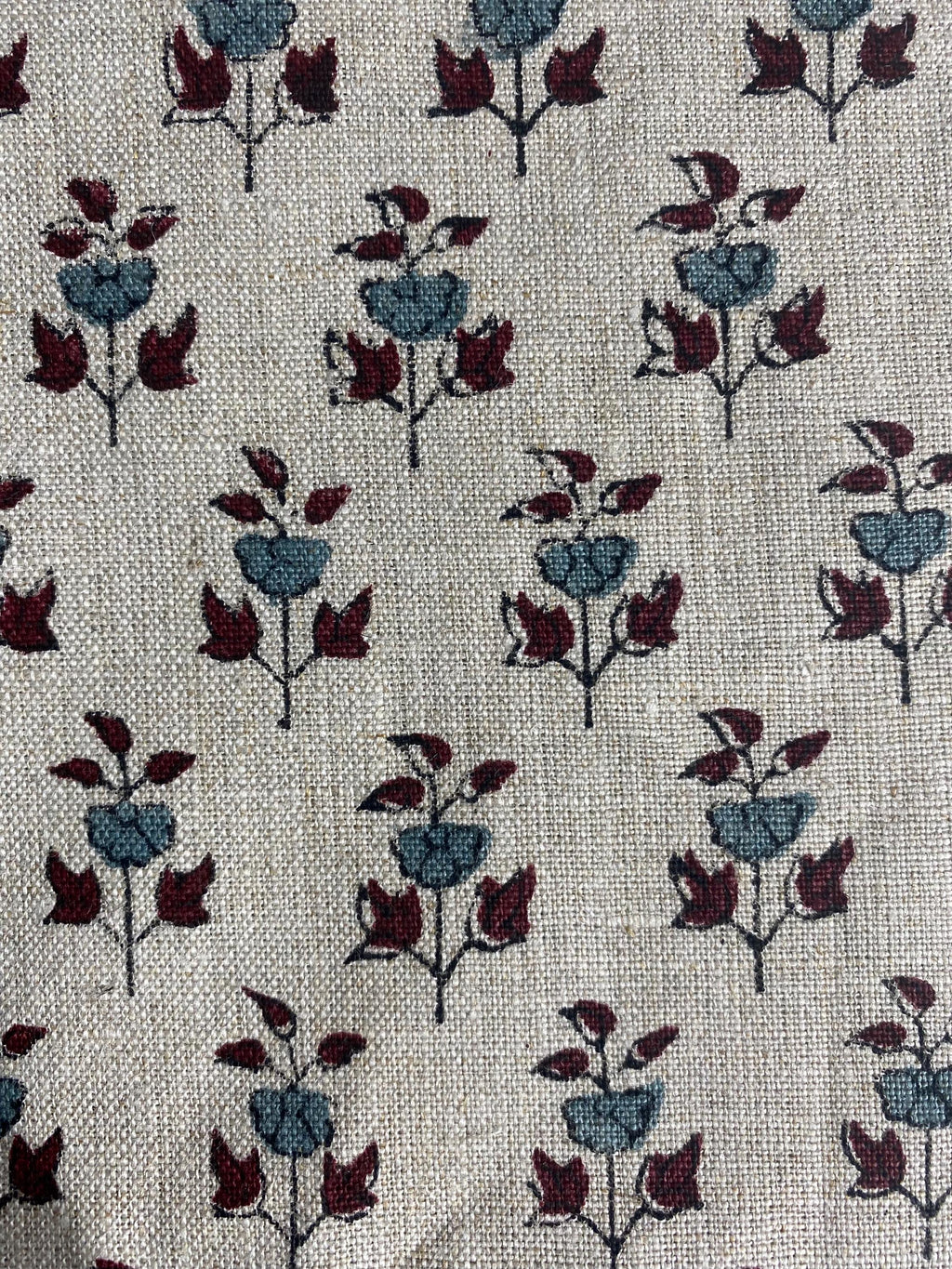 Hand block print linen pillow cover styled on a wooden stool