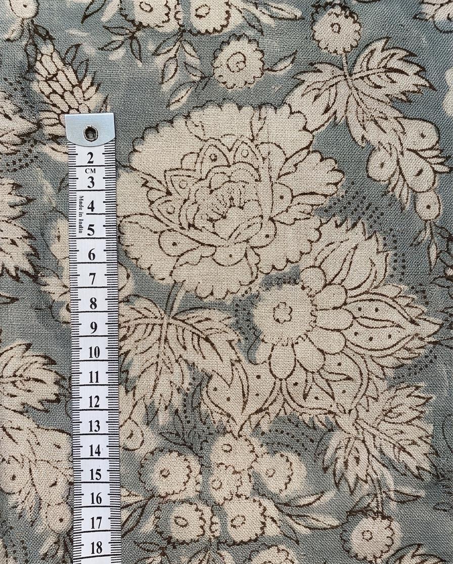 Blue-gray floral linen pillow cover styled in a living room
