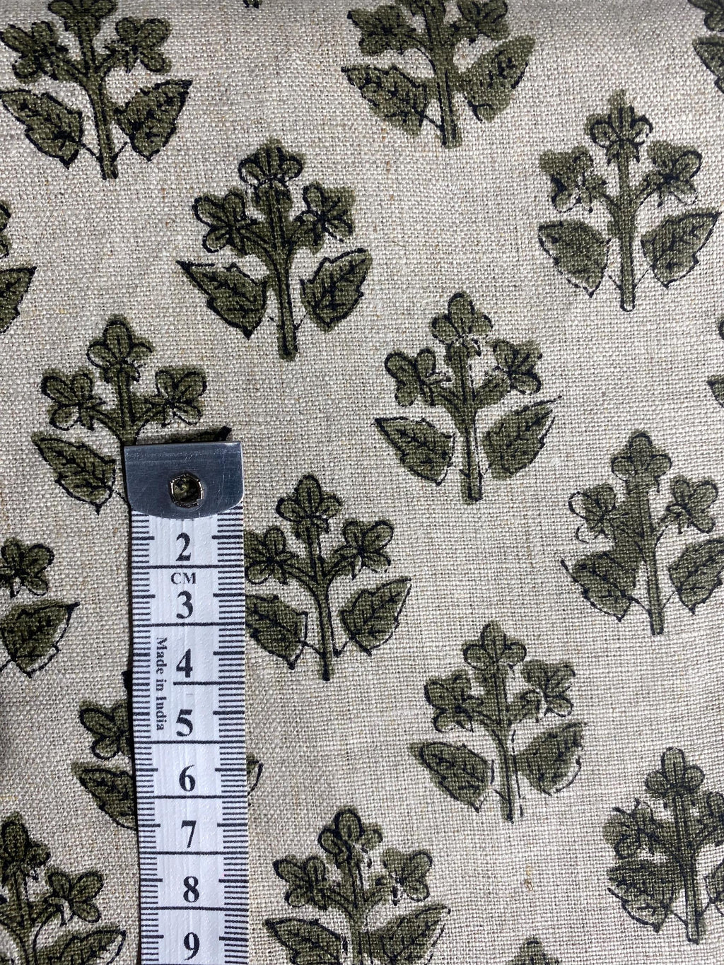 Olive green sprig hand block print linen pillow cover styled on a chair