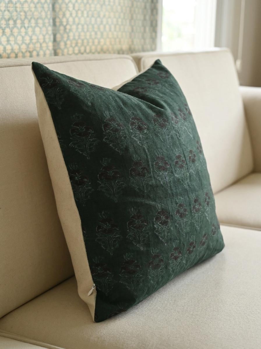 Forest green chintz bud linen cushion cover on a sofa