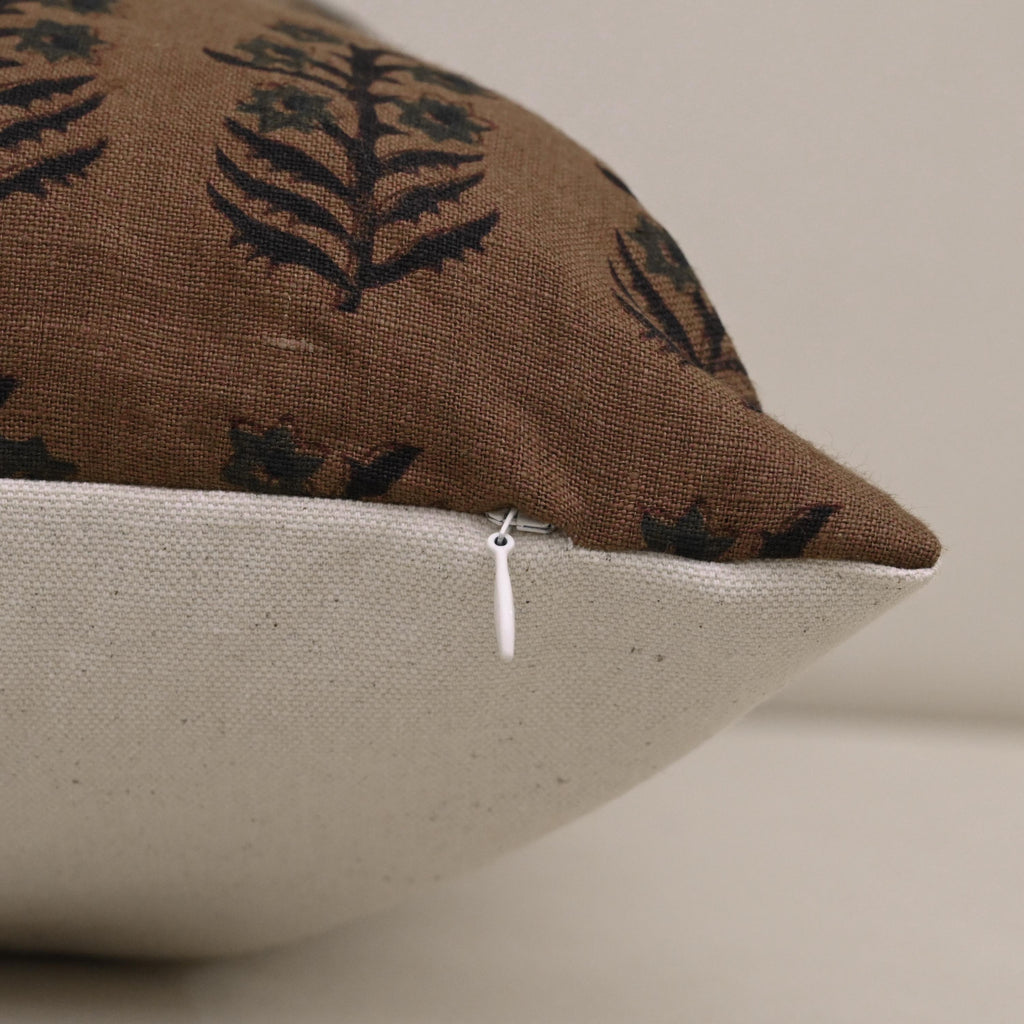 Brown floral linen cushion cover on a neutral armchair