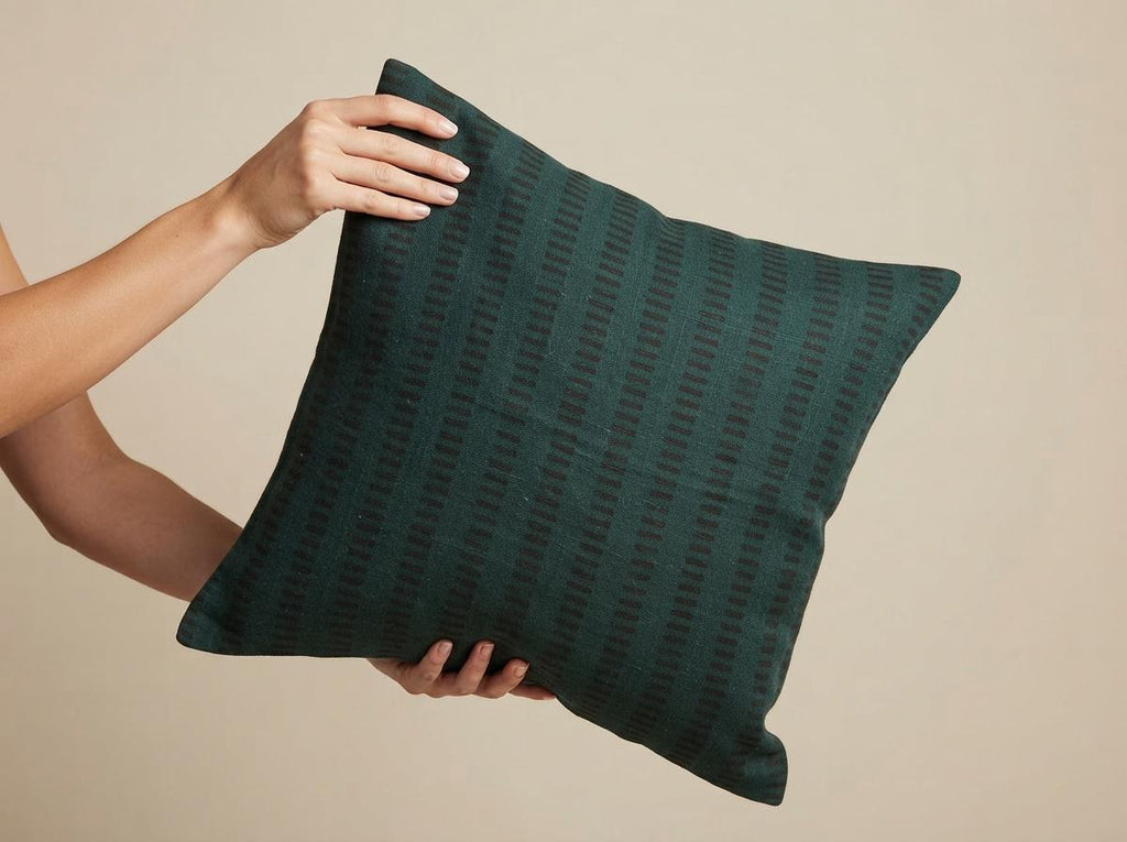 Forest green geometric stripe pillow cover styled in a living room