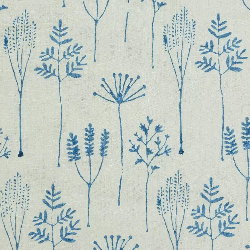 Blue botanical linen pillow cover styled on a sofa