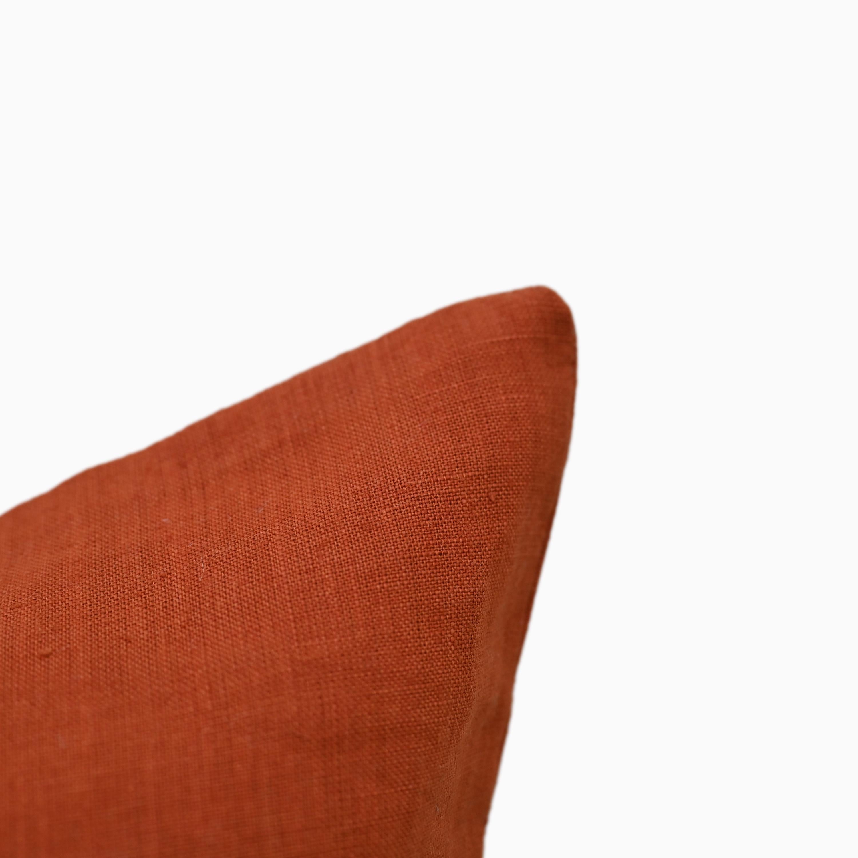 Close-up of burnt orange linen pillow cover fabric weave and edge