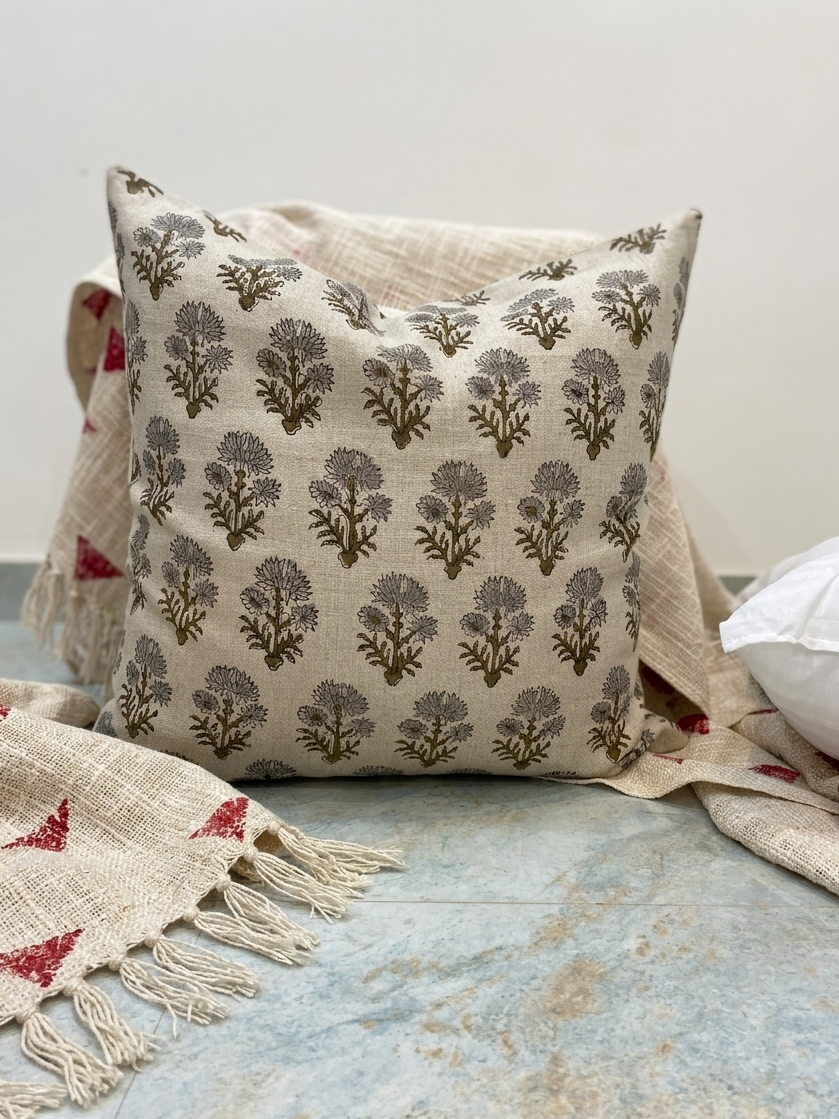 Block print linen pillow cover displayed on a marble floor with a striped cotton throw