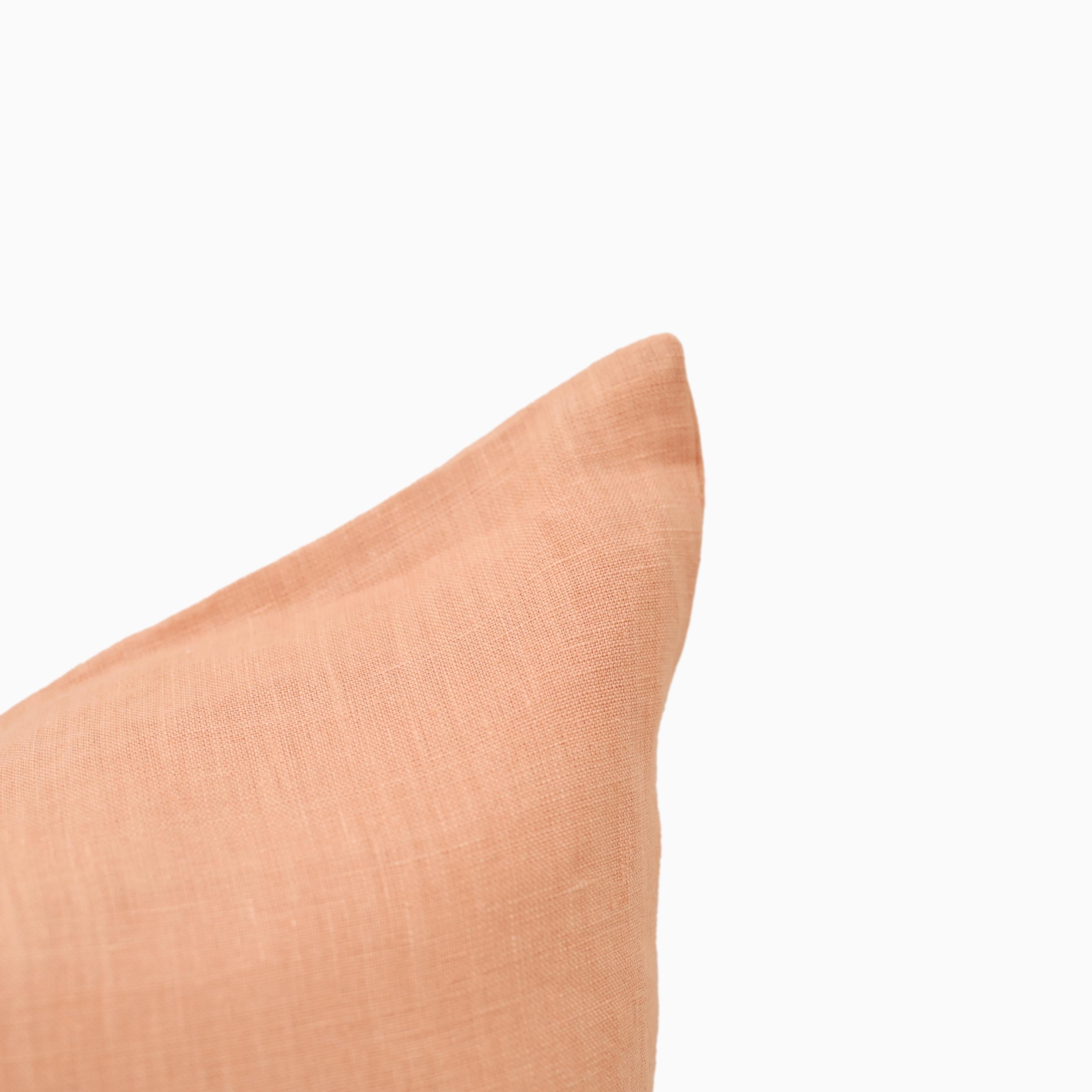 Close-up of peach linen pillow cover fabric texture and edge stitching