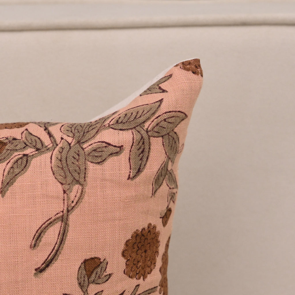 Peach floral linen cushion cover styled on a sofa