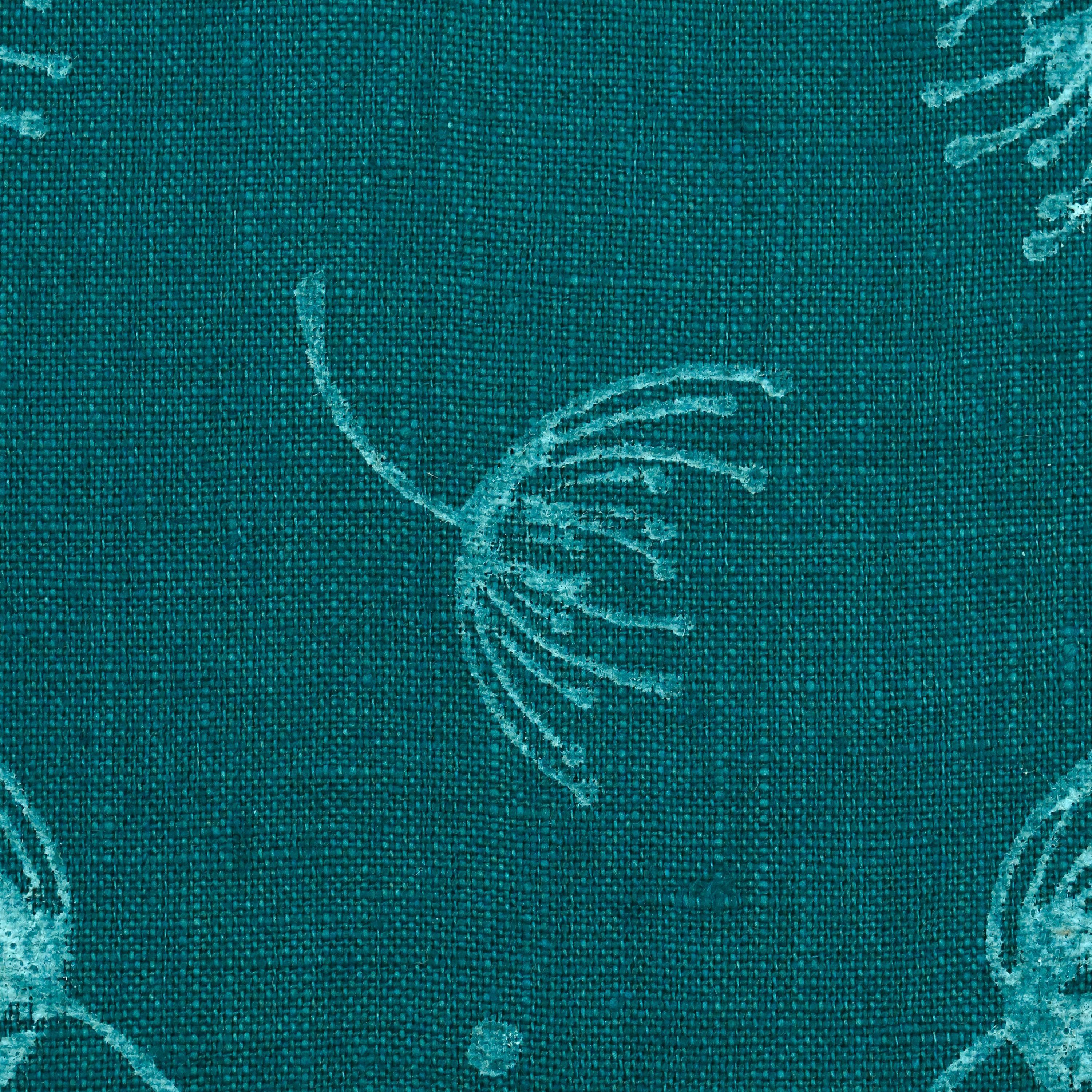 Close-up of hand block printed dandelion sprigs on teal linen