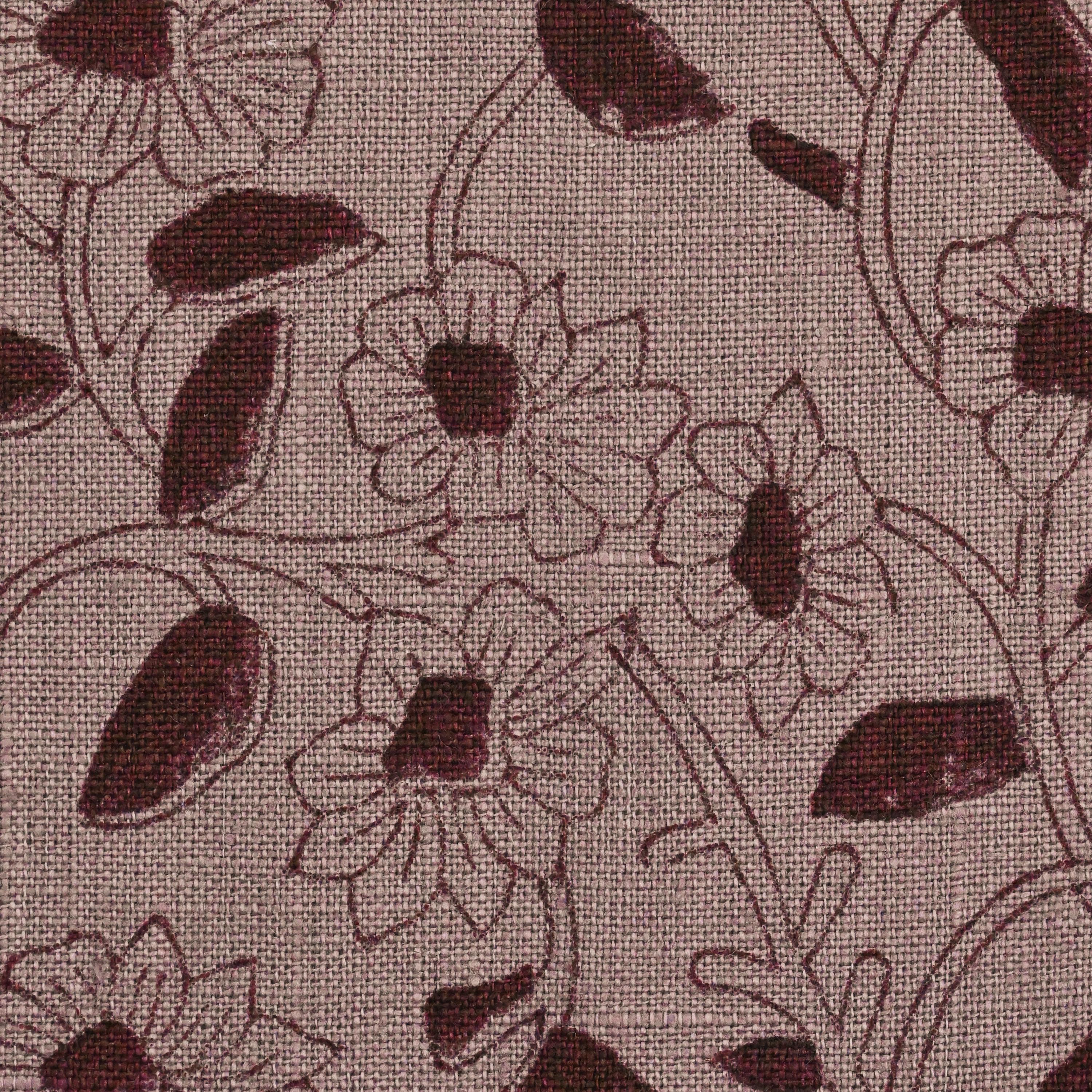 Close-up of the burgundy ditsy daisy block print detail on mauve linen