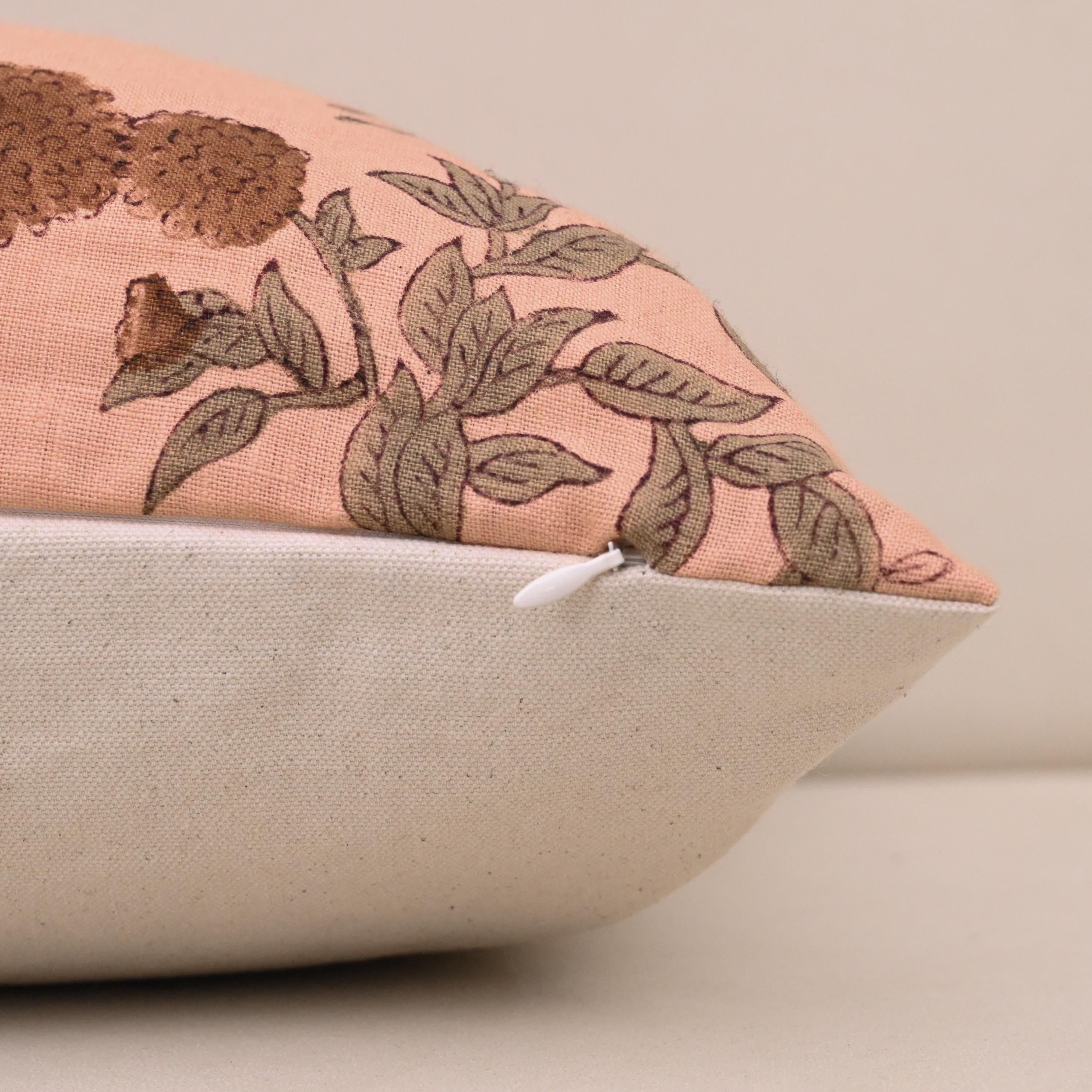 Close-up of rust floral block print detail on peach linen cushion cover