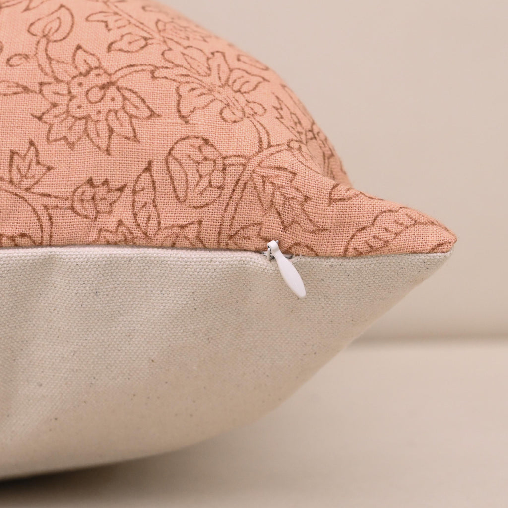 Blush peach floral linen pillow cover styled on a sofa