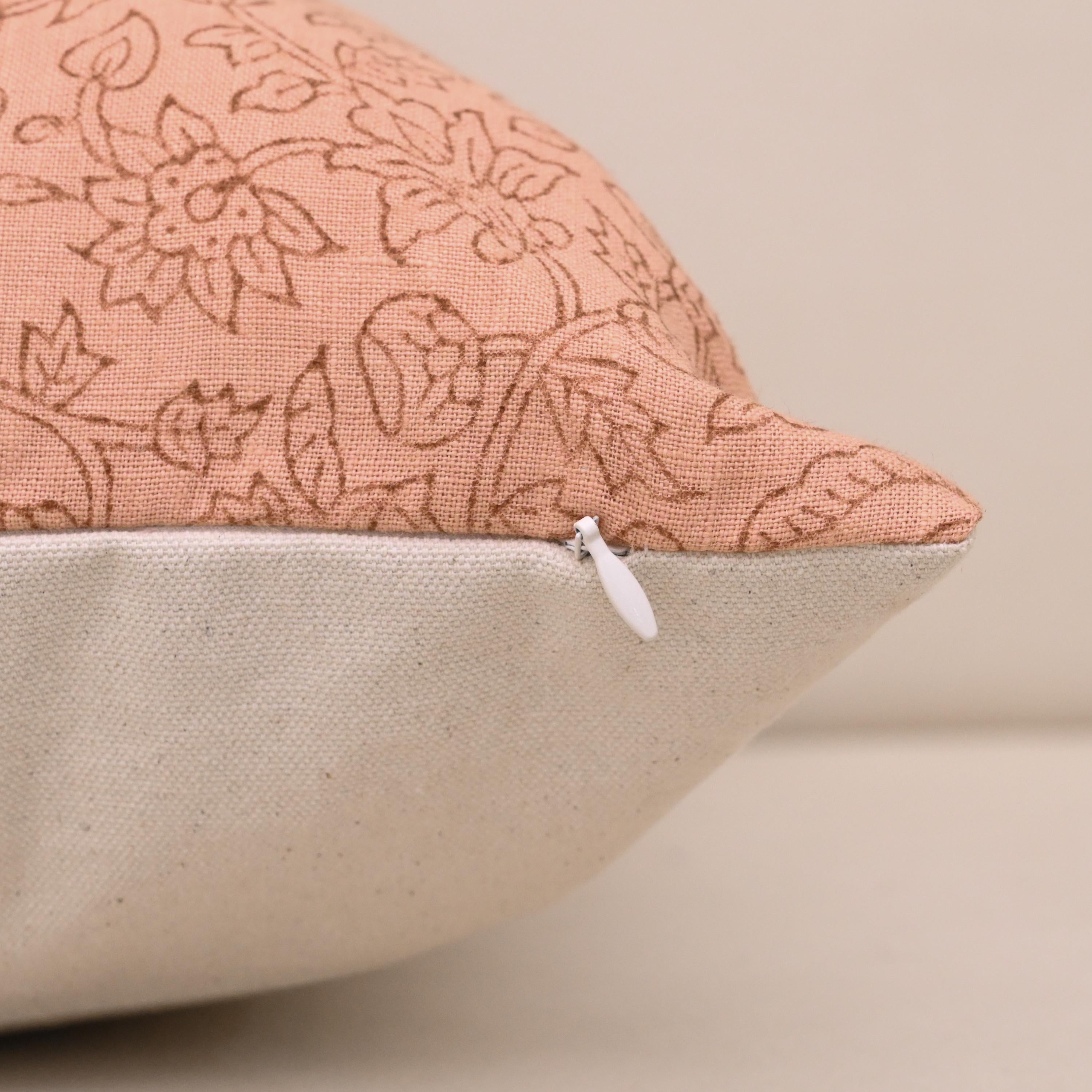 Blush peach floral linen pillow cover styled on a sofa