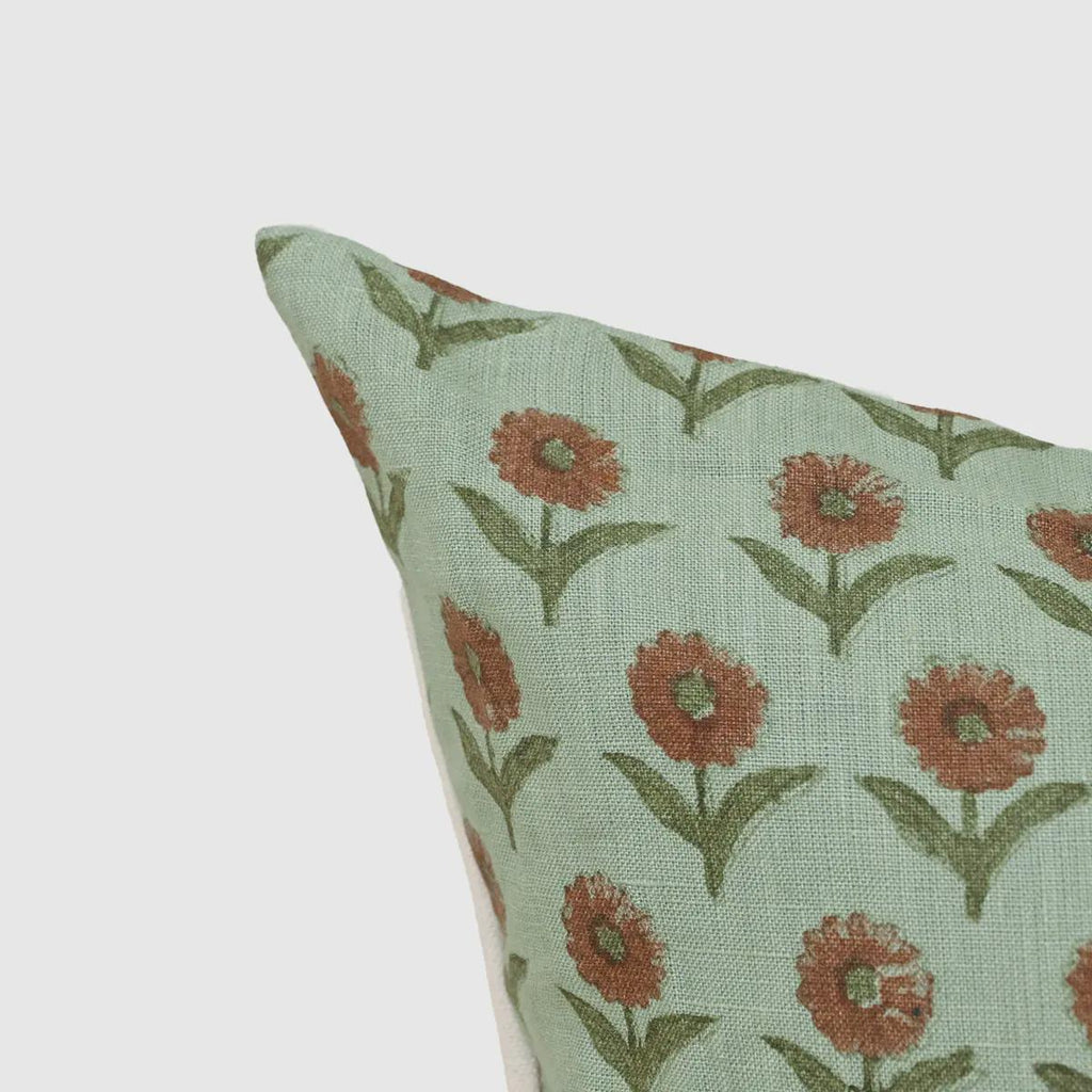 Close-up of rust-orange marigold buti print on sage green linen