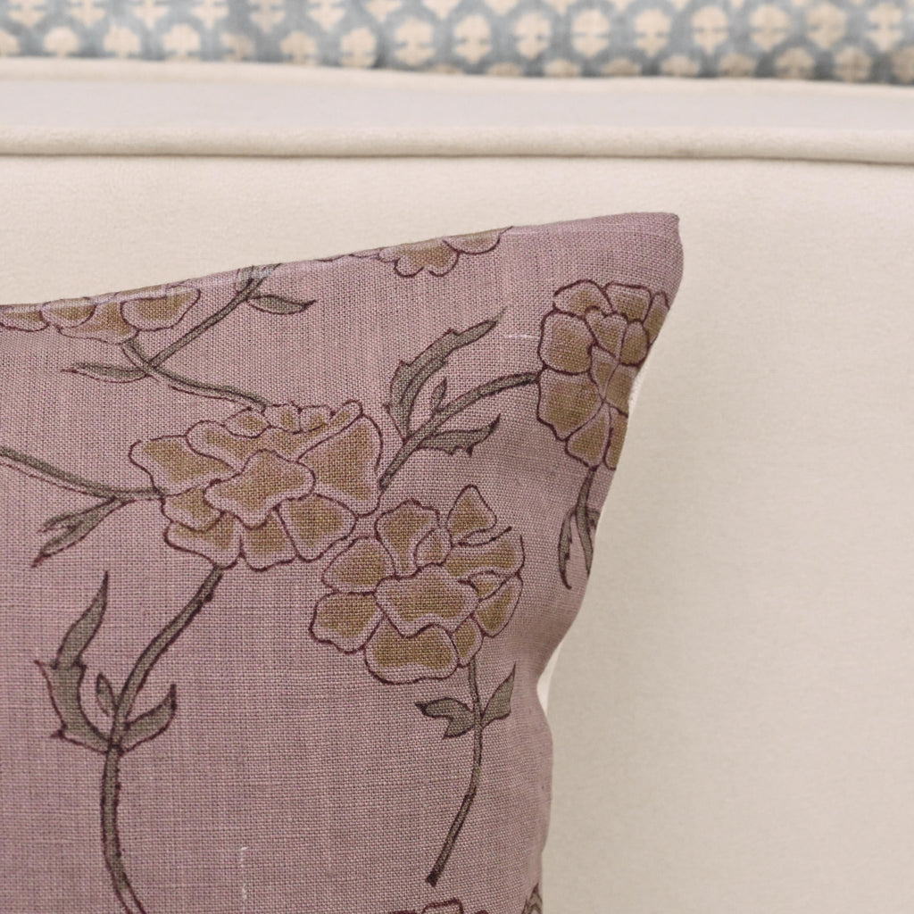 Mauve floral linen cushion cover styled on a sofa