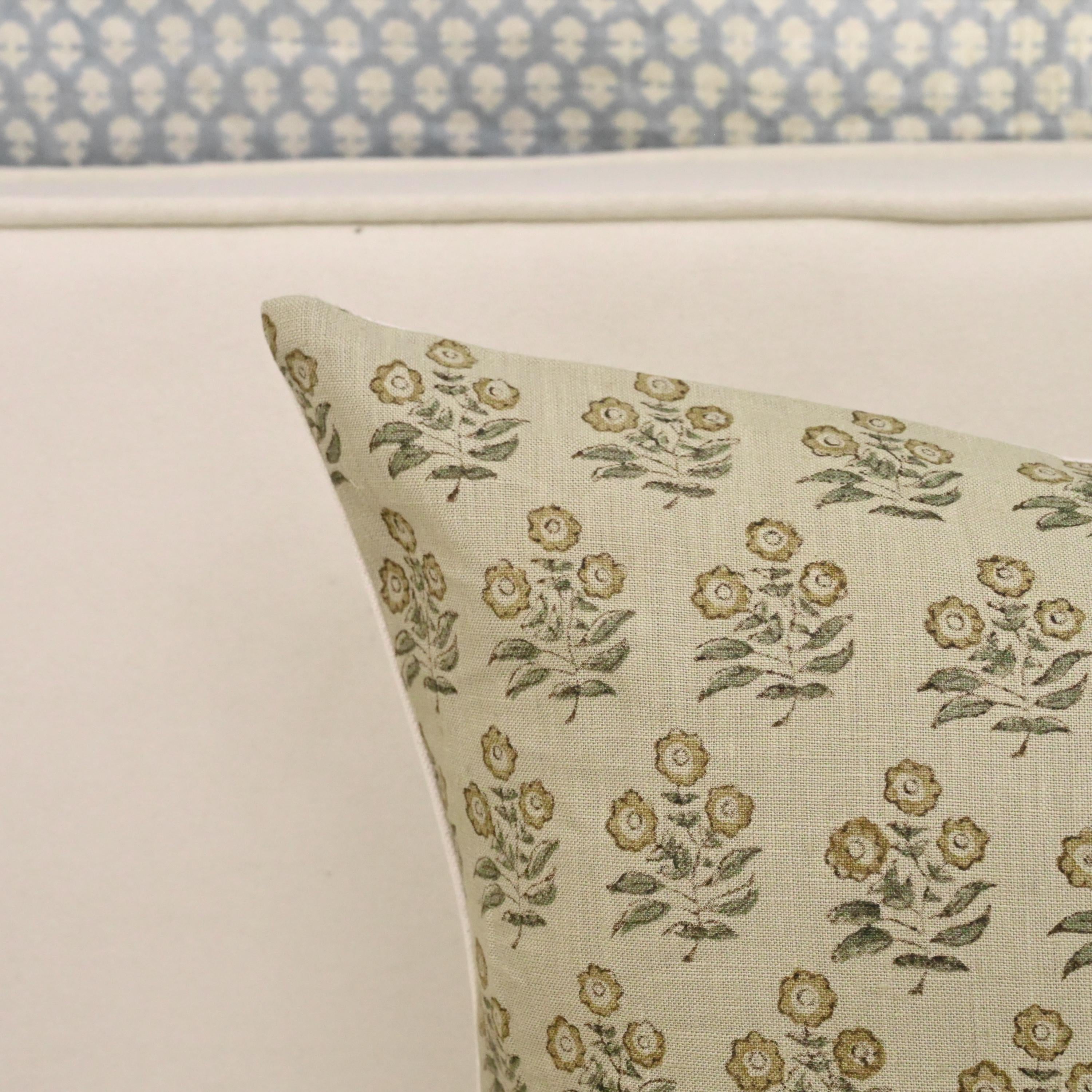 Close-up of golden floral block print detail with sage leaves on linen pillow cover