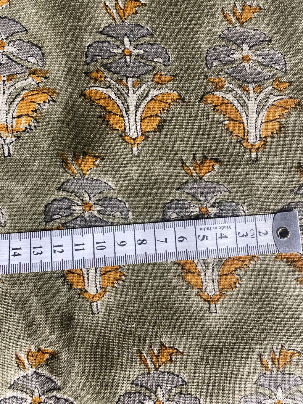 Sage green floral buti hand block print linen pillow cover styled on a chair