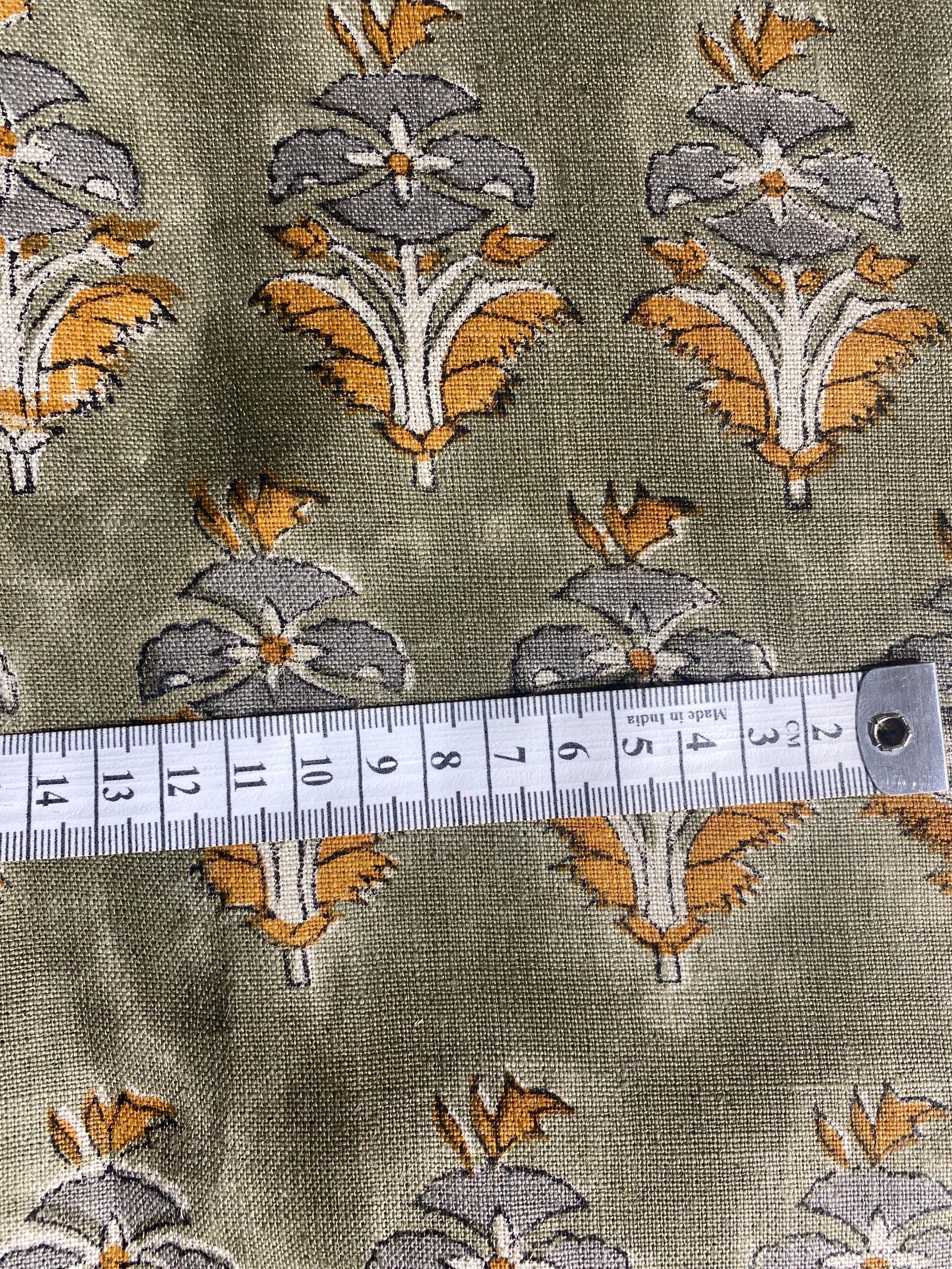 Sage green floral buti hand block print linen pillow cover styled on a chair