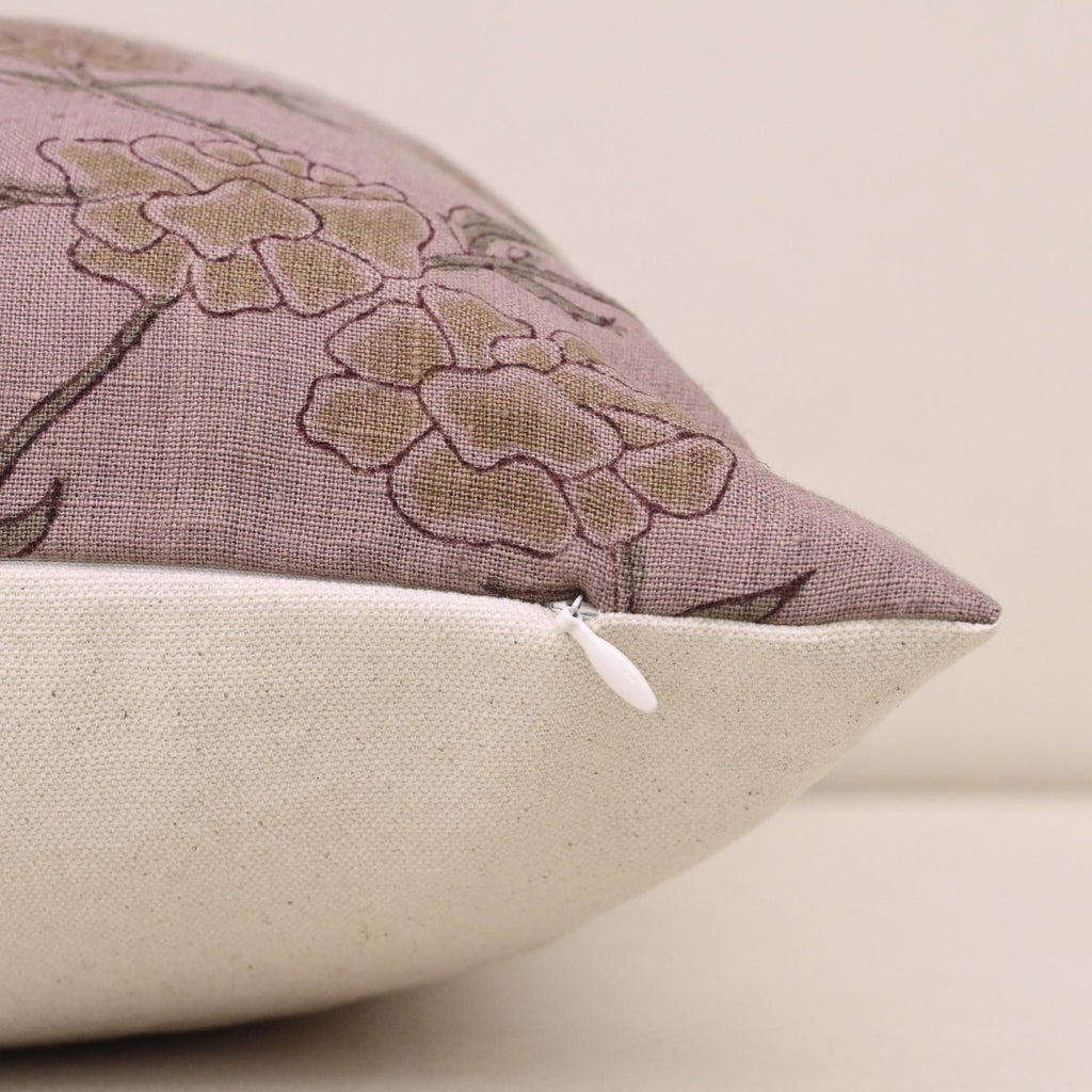 Close-up of gold floral block print detail on mauve linen cushion cover